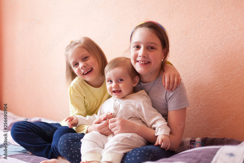 Portrait of three sisters on bed at home. Portrait of three sisters on bed at home.