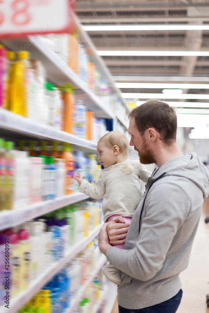 young father with   small baby shopping at  supermarket.