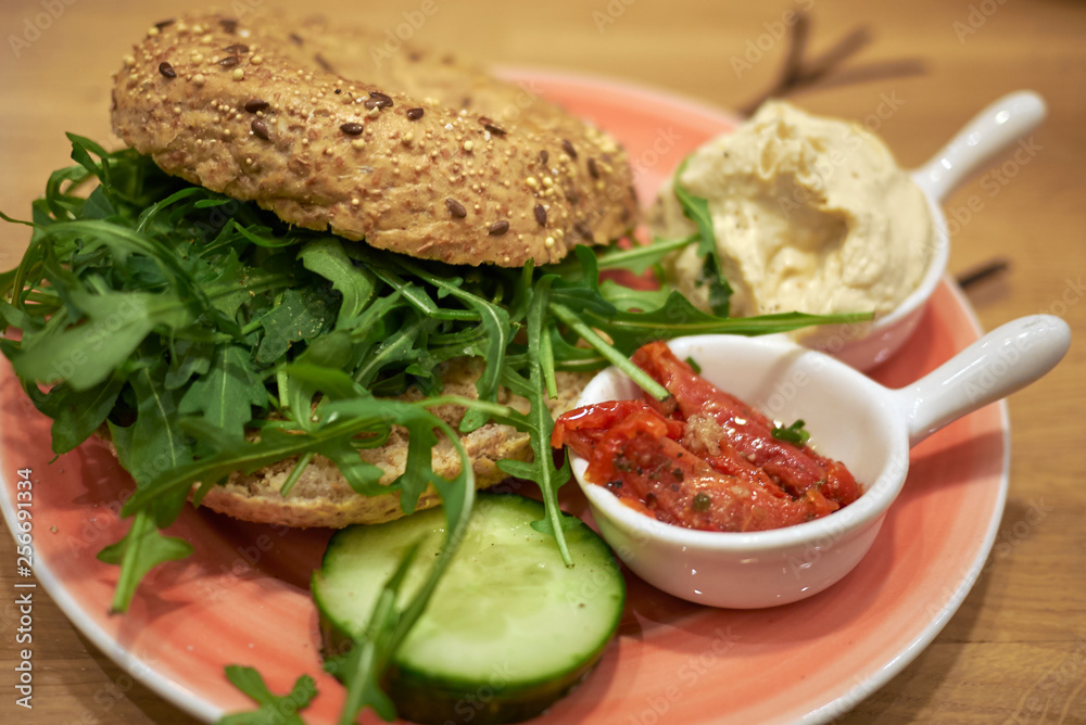 Vegetarian bagel with rocket, hummus and tomatoes Vegetarian bagel with rocket, hummus and tomatoes