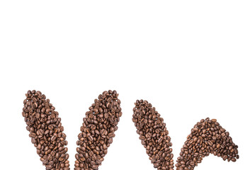 Easter holiday background with bunny ears made of freshly roasted coffee beans on a white background. Creative easter concept. Copy space.