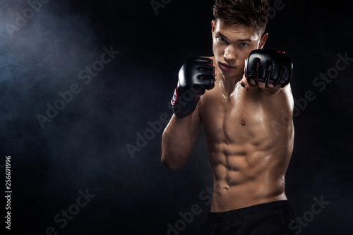 Sportsman boxer fighting on black background with smoke. Copy Space. Boxing sport concept. © Mike Orlov