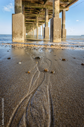 sea tide sandy beach below pier © anastasiaarsentyeva