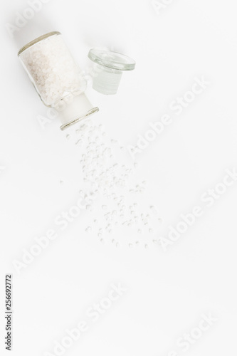 Pure Natural Coarse Sea Salt Spilling Out of A Vial On White Background