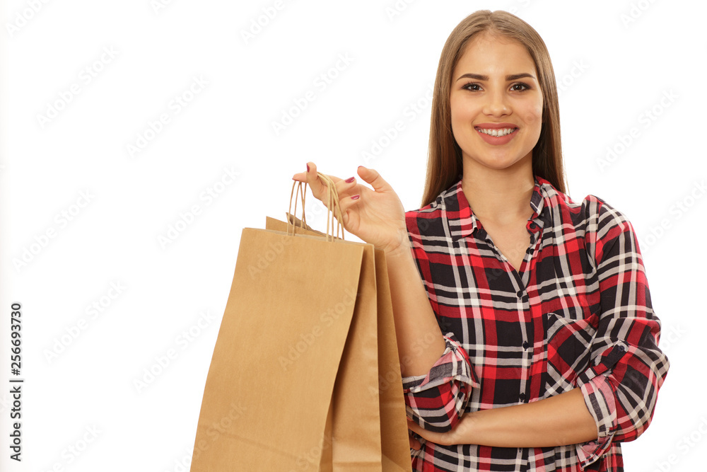 Happy young beautiful woman smiling to the camera posing with shopping bags isolated copy space. Cheerful attractive female shopper holding paper bags. Consumerism, buying, fashion concept Happy young beautiful woman smiling to the camera posing with shopping bags isolated copy space. Cheerful attractive female shopper holding paper bags. Consumerism, buying, fashion concept