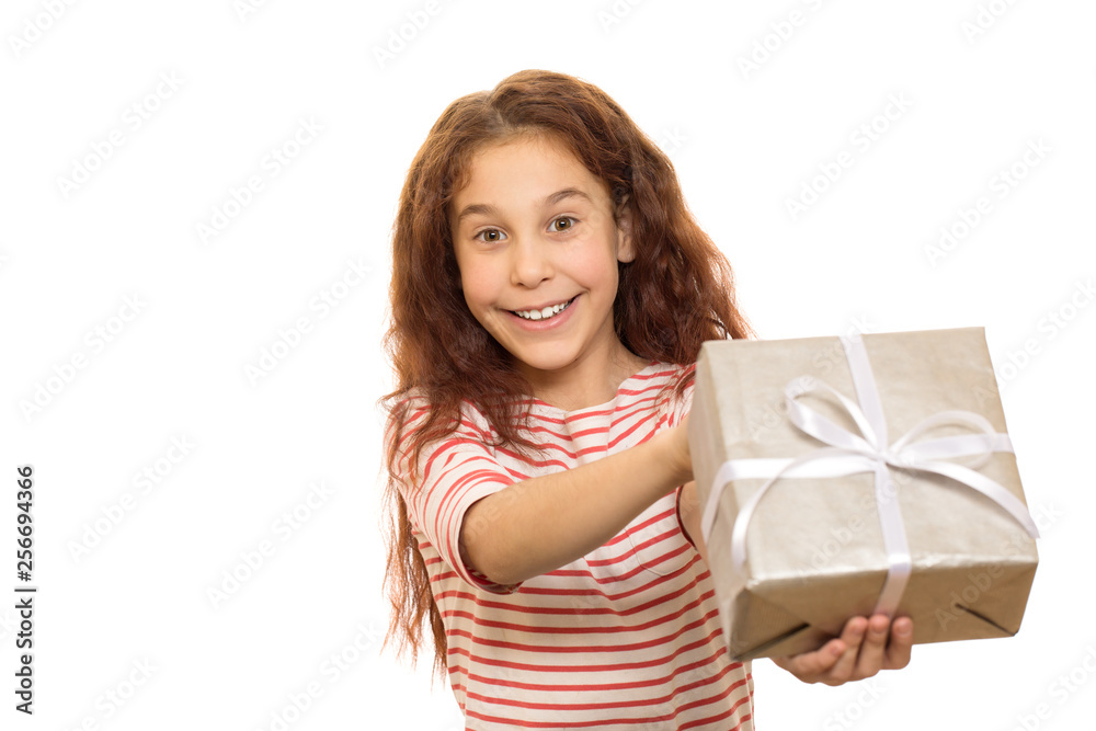 Happy young beautiful girl smiling joyfully holding out Christmas present to the camera isolated on white copyspace gift celebrating festive childhood happiness emotions x-mas wrapped bow