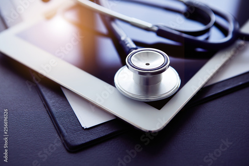 Close up of stethoscope and tablet on table. Medicine and technology concept
