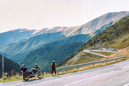Woman with adventure motorcycle. Motorbike rider. Top of mountain road. Motorcyclists vacation. Travel and active lifestyle Transfagarasan Romaia, copy space © Sergey