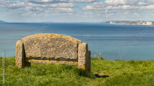 Stone bench at the South West Coast Path with a view over the Jurassic Coast, near Worth Matravers, Jurassic Coast, Dorset, UK photo