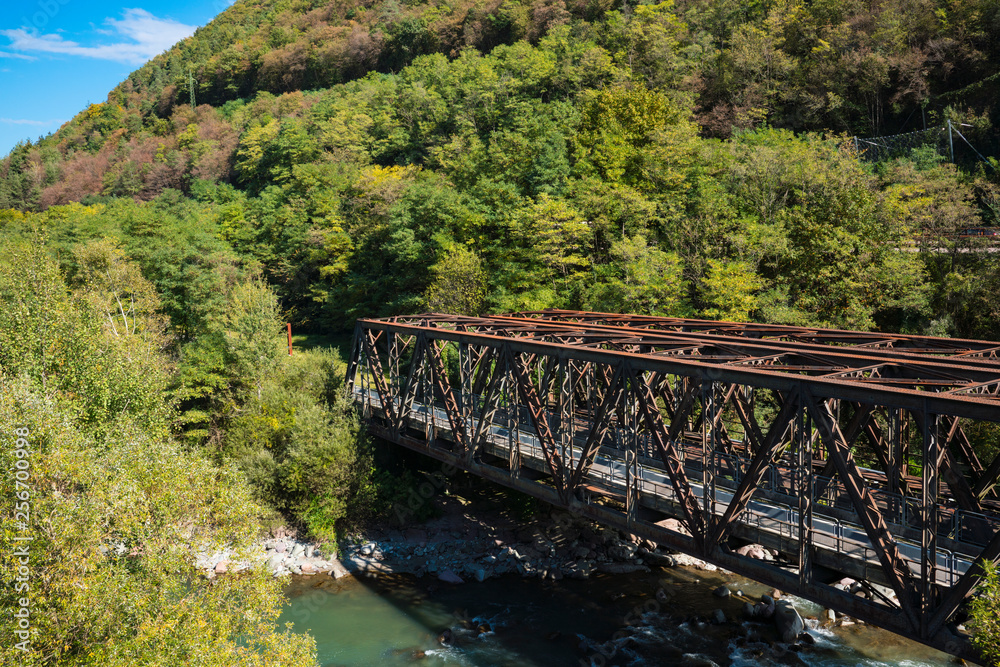 brown railway bridge over river Adige, Trentino, Italy brown railway bridge over river Adige, Trentino, Italy