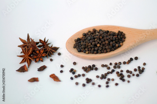 Spices in wooden spoon isolated on white background.