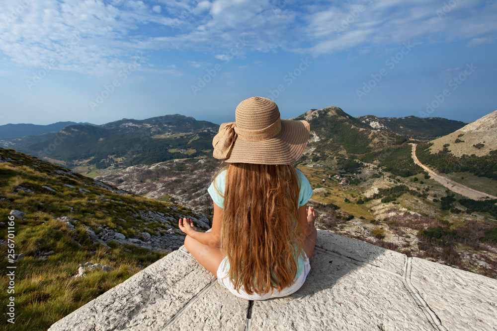 Girl on mountain top sitting and admire the view