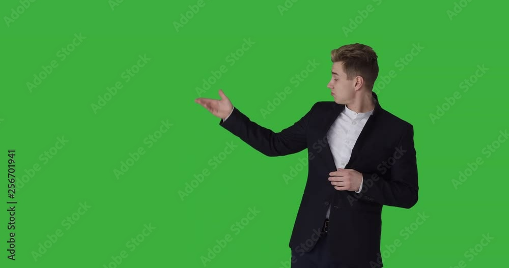 Businessman giving thumbs up and ok sign while pointing at green chroma key background Businessman giving thumbs up and ok sign while pointing at green chroma key background