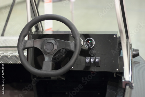 Captain's place in the cockpit of a utilitarian motor boat - steering wheel and dashboard