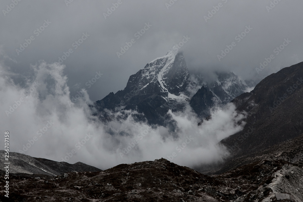 huge Himalayan mountain  with a glaciers in Nepal covered by clouds