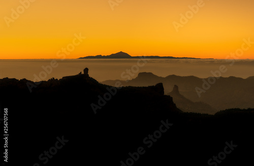 beautiful panoramic view of volcano Teide of Tenerife and Pico Roque Nublo of Gran Canaria during golden sunset