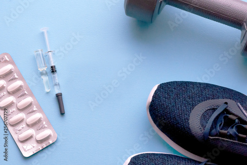 The concept of doping in sport. Sports shoes, pills, syringe with medicine, fillett.