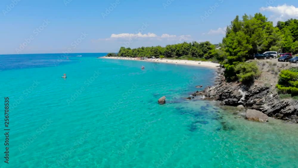 Aerial drone view of blue sea surface on sandy beach surrounded with trees. Top view of transparent turquoise ocean water surface, seashore, forest. Aerial drone view of blue sea surface on sandy beach surrounded with trees. Top view of transparent turquoise ocean water surface, seashore, forest.