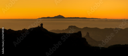 beautiful panoramic view of volcano Teide of Tenerife and Pico Roque Nublo of Gran Canaria during golden sunset