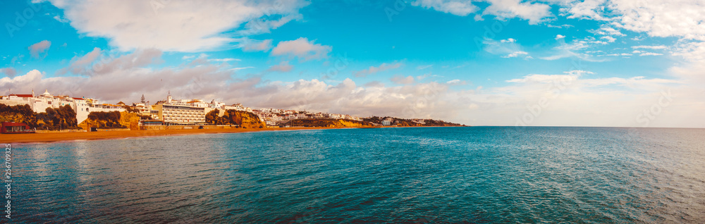 big 180 degree panoramic picture of albufuera at portugal with the ocean and colorful sky