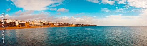 big 180 degree panoramic picture of albufuera at portugal with the ocean and colorful sky