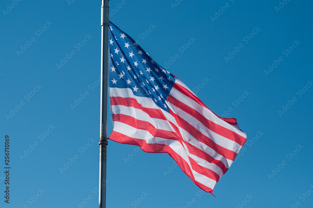closeup of american flag on blue sky background closeup of american flag on blue sky background