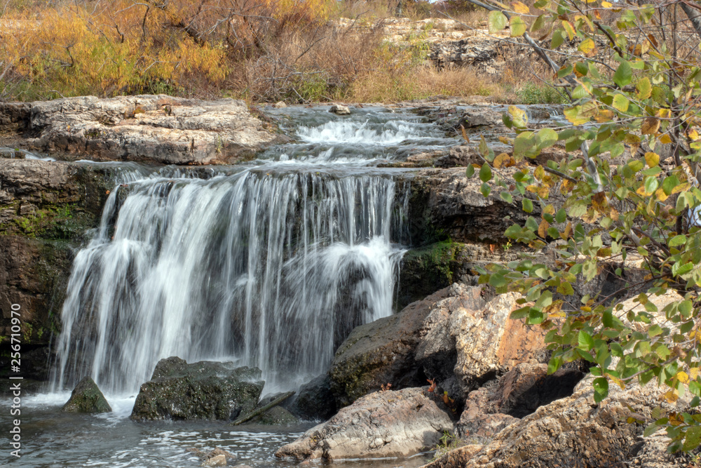 Water flows smooth and gracefully over the rocks at The Falls in Joplin, MO on an autumn day. Water flows smooth and gracefully over the rocks at The Falls in Joplin, MO on an autumn day.