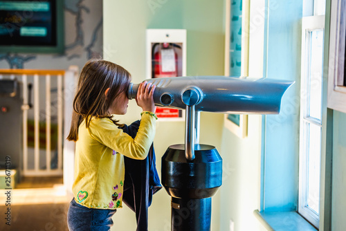a little girl looking through the binoculars 
