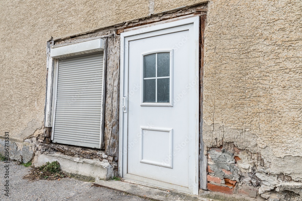 Eine beschädigte Hausmauer und abgeplatzter Außenputz mit einem großen Loch, Deutschland