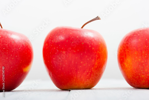 apple fruits in a row, white wooden table background