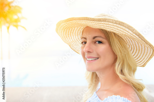beautiful woman on the terrace of prestigious hotel, with palm on the background and sunset