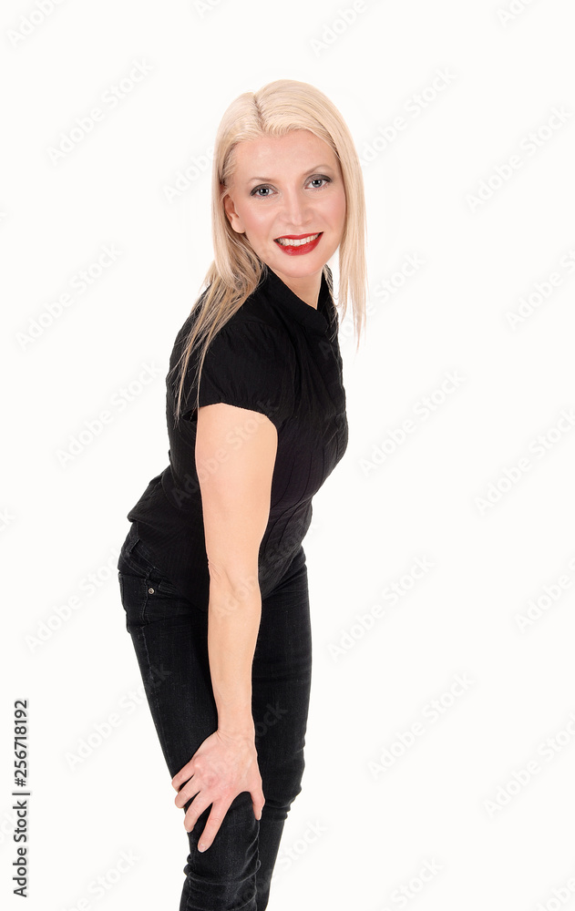 A happy looking blond woman standing in black outfit A happy looking blond woman standing in black outfit