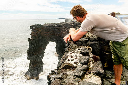 A man at the Holei Sea Arch, Hawaii Volcanoes National Park photo