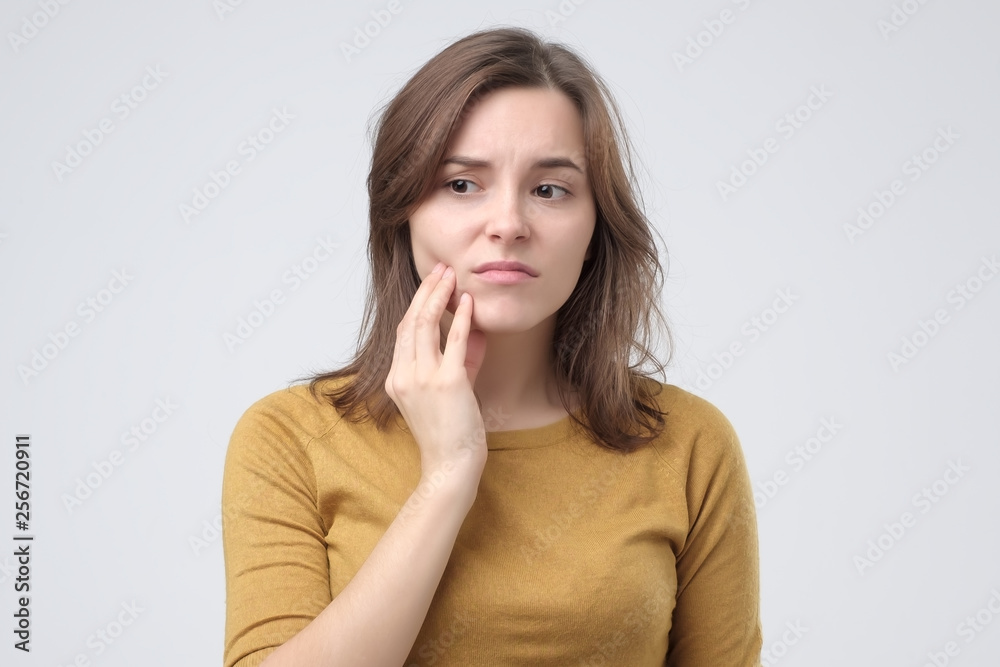 Studio shot of young woman with tooth pain. Studio shot of young woman with tooth pain.