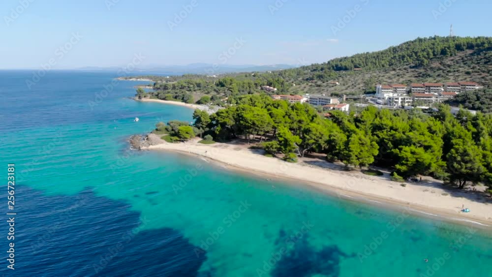 Aerial drone view of blue sea surface on sandy beach surrounded with trees. Top view of transparent turquoise ocean water surface, seashore, forest. Aerial drone view of blue sea surface on sandy beach surrounded with trees. Top view of transparent turquoise ocean water surface, seashore, forest.