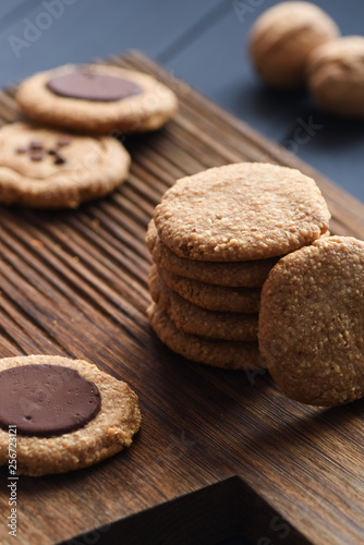 Homemade healthy gluten free sugar free vegetarian sweets. Peanut butter cookies with dark chocolate drops on dark oak board