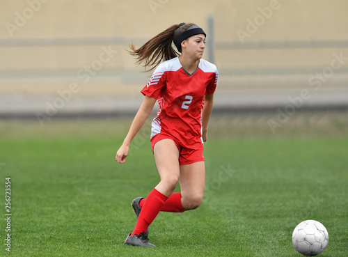 Young Girl Playing soccer, kicking the ball © Joe