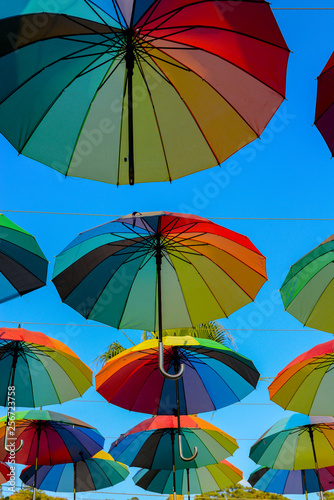Rainbow colored umbrellas hanging on the sky vertical image