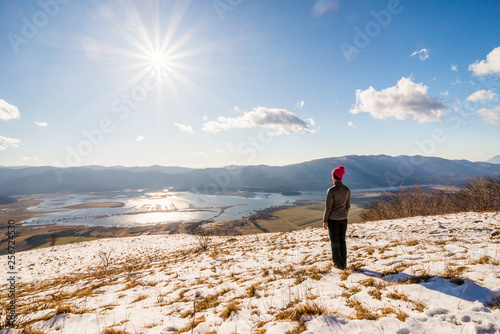 Young woman is enjoying the view over Lake Cerknica on a sunny winter day in Slovenia.