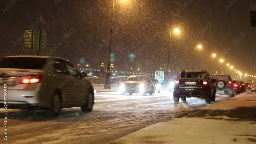 Cars driving on city street in winter at night Cars driving on city street in winter at night