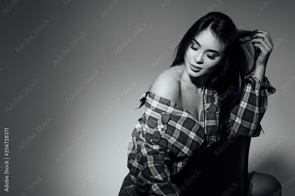 Beautiful girl inred t-shirt with long and beautiful hair on dark background and white Beautiful girl inred t-shirt with long and beautiful hair on dark background and white