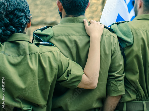 Israeli soldiers with flag of Israel on blurred background of Western Wall