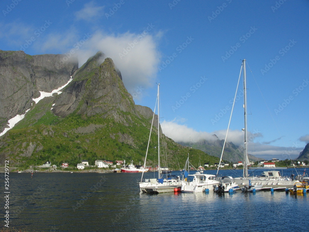 Small private Lofoten harbour with sailboat in sunny day with blue sky