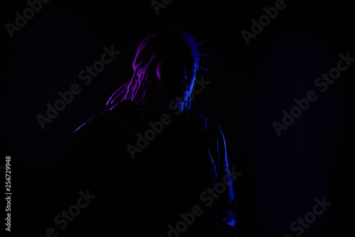 beautiful profile girl in the light of neon colored lamps light blue purple contours, girl silhouette. on black background