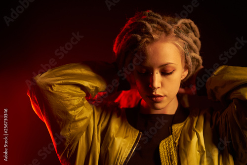 beautiful girl in the light of neon colored lamps light yellow red on black background