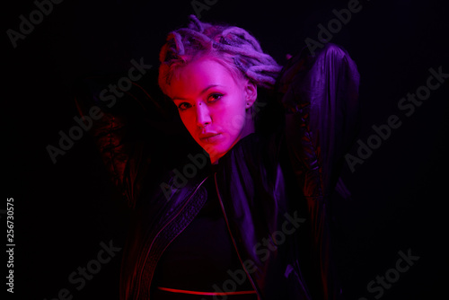 beautiful girl in the light of neon colored lamps light purple red on black background