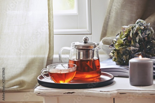 Hygge cozy home interior.  Candles, book and cup of tea