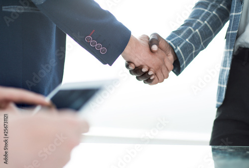 close up. handshake business people standing at the Desk