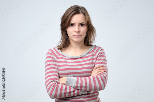 Young serious european woman portrait looking with irritation at camera.
