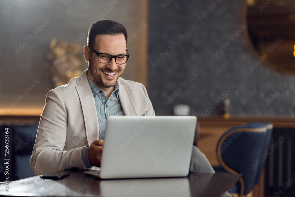 Happy mid adult man relaxing in a cafe and using laptop. Happy mid adult man relaxing in a cafe and using laptop.