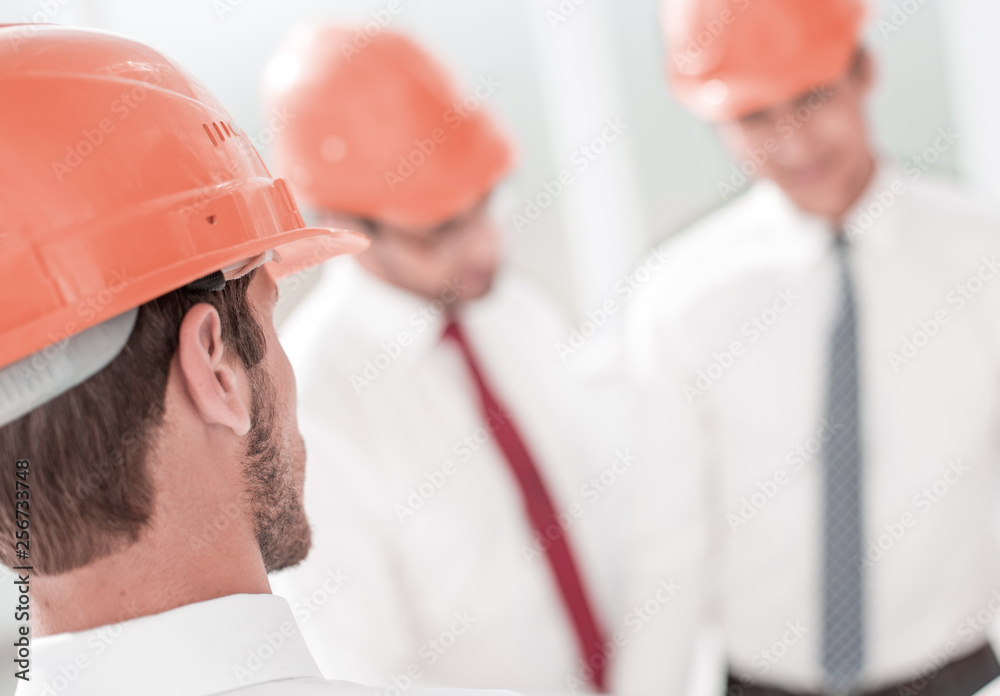 close up. the architect in the protective helmet looks into his office close up. the architect in the protective helmet looks into his office